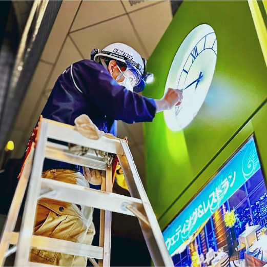 時計台の細かい汚れを丁寧に清掃・チェックする清掃士